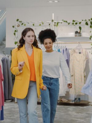 Two women exploring fashion trends in a stylish boutique together.